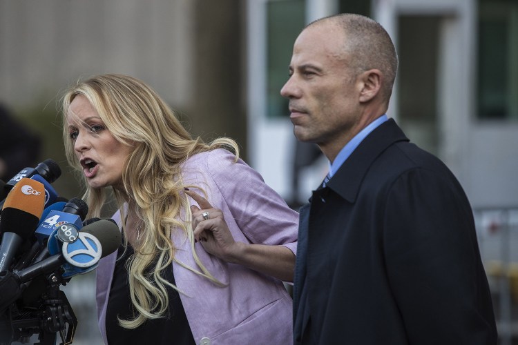 Adult-film actress Stormy Daniels, left, speaks to members of the media outside Federal Court in New York in April. At right is her attorney, Michael Avenatti. In new documents, President Trump reported reimbursing his personal attorney over $100,000 last year – an apparent reference to the $130,000 that Cohen paid to ensure Daniels' silence before the election about an alleged affair with Trump. 