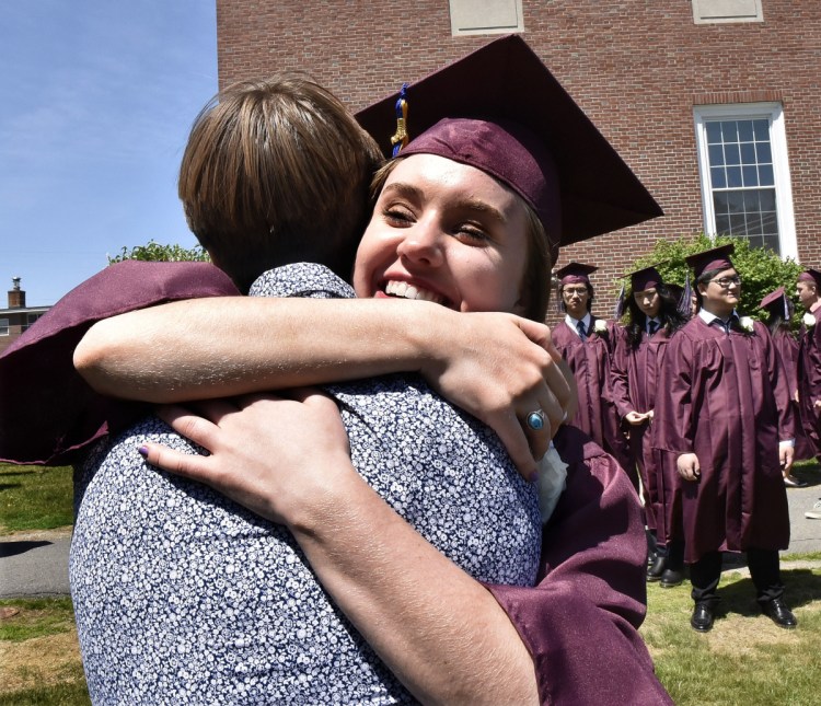 Maine Central Institute student Hannah Folan hugs friend Arjan Orr prior to commencement in Pittsfield on Sunday.