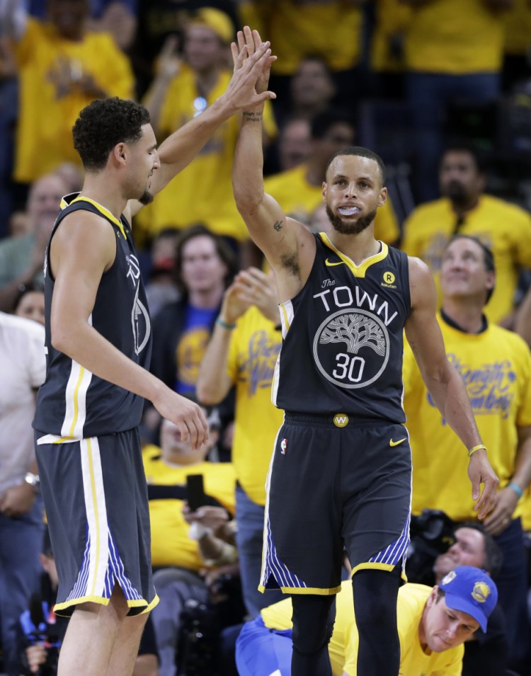 Golden State Warriors guard Stephen Curry (30) celebrates with guard Klay Thompson (11) during the second half of Game 2 of basketball's NBA Finals in Oakland, Calif., Sunday, June 3, 2018. (AP Photo/Marcio Jose Sanchez)