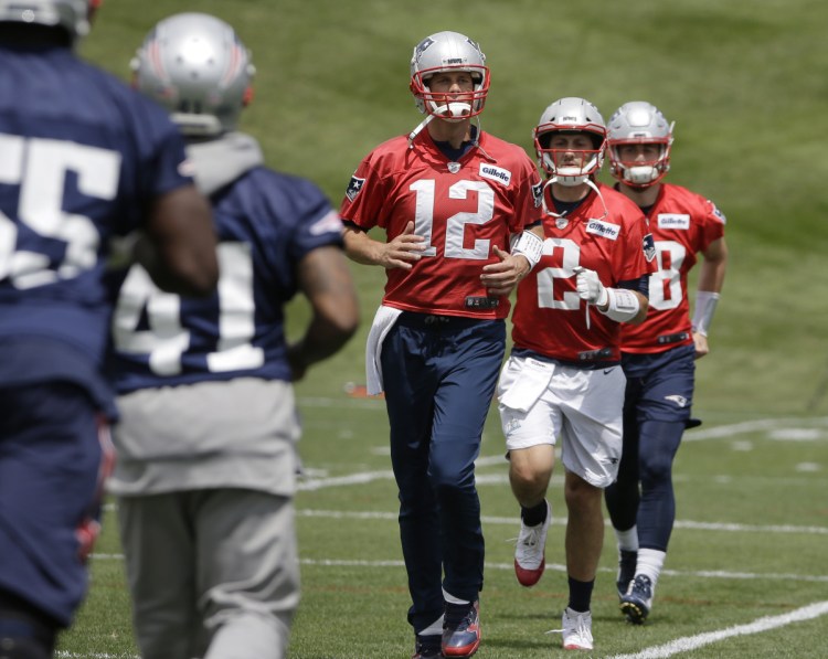 New England Patriots quarterbacks Tom Brady (12) Brian Hoyer (2) and Danny Etling, behind right, warm up during an NFL football minicamp practice, Tuesday, June 5, 2018, in Foxborough, Mass. ()
