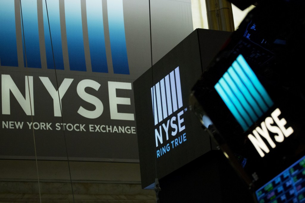 Signs for the New York Stock Exchange hang above the trading floor in May. Banks and bond yields climbed Wednesday, lifting the market to its fourth gain in a row, Associated Press/Mark Lennihan