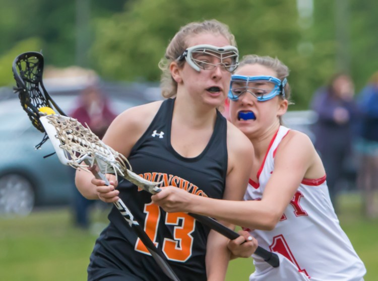 Cony defender Sierra Clark, right, tries to knock the ball away from Brunswick's Lila Solberg during a Class B lacrosse playoff game Wednesday in Augusta. Brunswick won, 9-7.