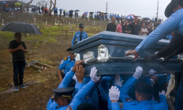 Police in Aguada, Puerto Rico, last Sept. 29 lift the coffin of officer Luis Angel Gonzalez Lorenzo, killed while trying to drive across a river during Hurricane Maria. The storm's toll reflects neglect and mismanagement.