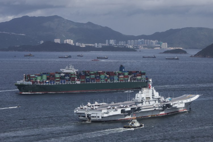 The People's Liberation Army Liaoning aircraft carrier, bottom, sails past a container ship in Hong Kong on July 7, 2017.