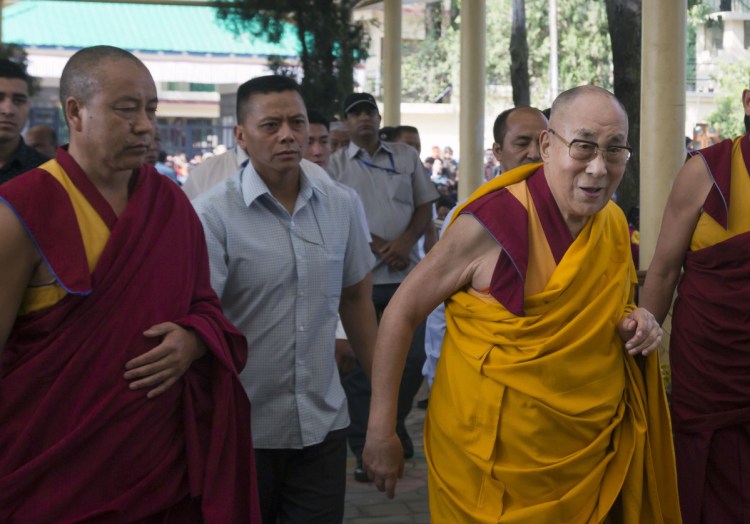 Tibetan spiritual leader the Dalai Lama, in a yellow robe, arrives to give a talk to Tibetan youths in Dharmsala, India, on Thursday. The Chinese government is stepping up its longtime campaign against the Dalai Lama in Tibet, where he has a significant following.