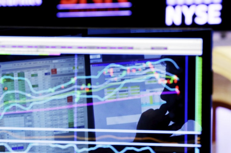 Specialist Anthony Rinaldi is silhouetted on a screen at his post on the floor of the New York Stock Exchange in this 2016 photo. Fears of a global trade war have given a boost to some of the biggest companies in the market as well as the smallest, but they've squeezed almost everything in the middle.