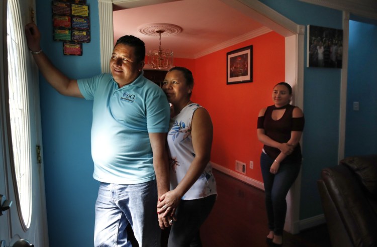 Nilson Canenguez, his wife, Judit, and their daughter Maybelin stand in their home in Morningside, Md. The couple must move back to El Salvador by September 2019.