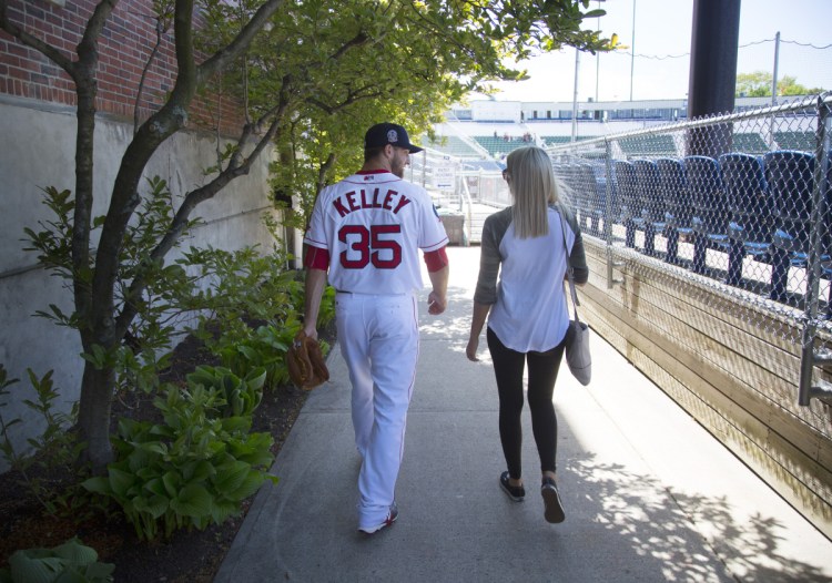 Portland Sea Dogs pitcher Trevor Kelley walks with his wife, Jamie, at Hadlock Field in Portland. With long hours and wages that amount to slightly more than Maine's minimum wage, playing in the minors is a challenge, Kelley says. "You just have to grind through it," he says. "It's more the opportunity. That's the way I think about it."