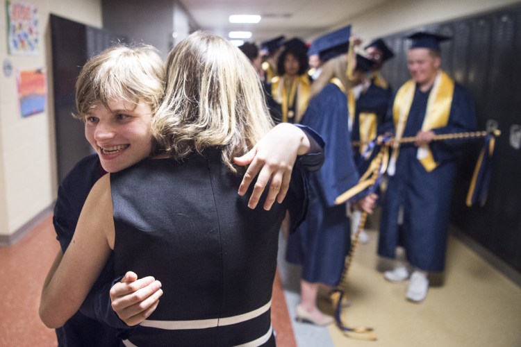 Leah Stinson hugs her personal ed tech, Alison Woodcock, with the 2018 Mt. Blue Senior High School graduating class in the hallway before commencement ceremonies at Mt. Blue High School in Farmington on Sunday.