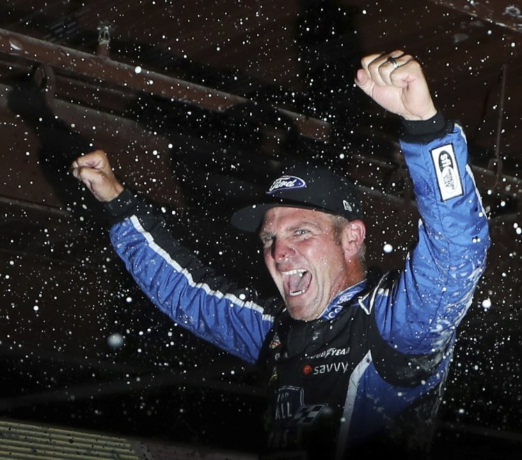 Clint Bowyer celebrates Sunday after winning a Cup Series race in Michigan that ended early because of rain.