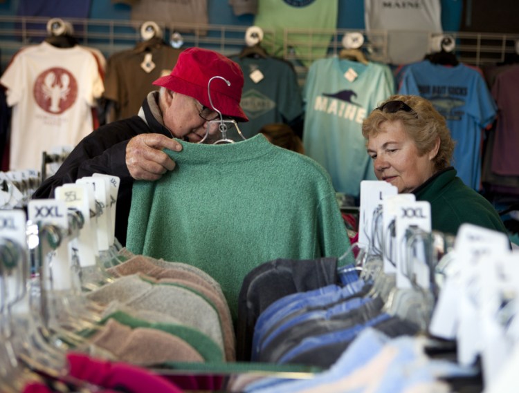 Bert and Dianne Shuey of Landisburg, Pa., peruse the shirts and sweatshirts at The Blue Lobster on Commercial Street on May 13, when three cruise ships docked in Portland. 