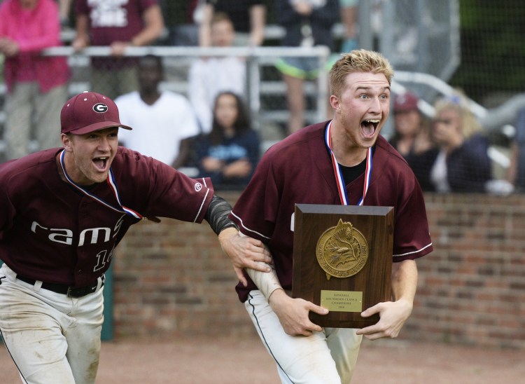 Gorham's Brogan McDonald, right, and Nolan Brown bring the trophy back to his teammates after the Rams defeated Cheverus on Tuesday for the Class A South title.