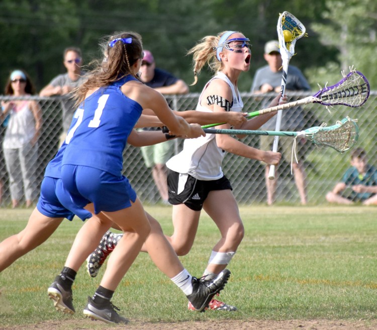 Caroline Gastonguay sets up the offense for St. Dom's against the defense of Erskine Academy's Olivia Kunesh, front, and Morgan Edmond during a Class C girls' lacrosse semifinal Tuesday.