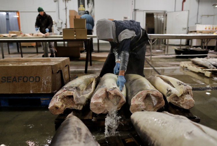 A fishmonger rinses swordfish carcasses just pulled from their shipping containers at the New Fulton Fish Market in New York on Jan. 8. The U.S. seafood industry is worth $17 billion a year, more than 90 percent of which is made up of imports. Experts say one in five fish is caught illegally worldwide.