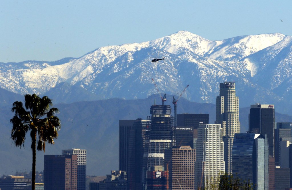 California voters will be asked this November if they want to split the state into three separate states: Northern California, which would include San Francisco, left; California, which would include Los Angeles, pictured in front of the snow-capped San Gabriel Mountains; and Southern California, which would get San Diego, seen here enveloped in smoke from a wildfire.