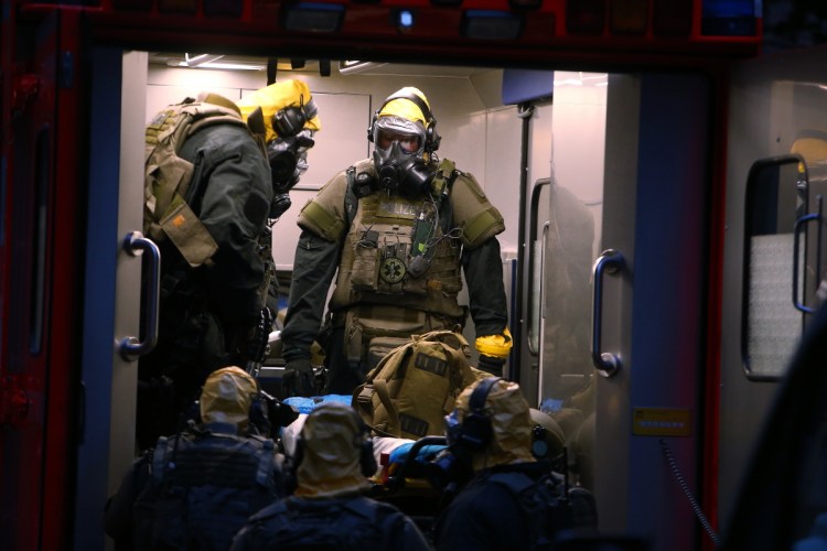 German police officers in protective gear enter a rescue car during an operation to search an apartment in Cologne, Germany, late Tuesday.