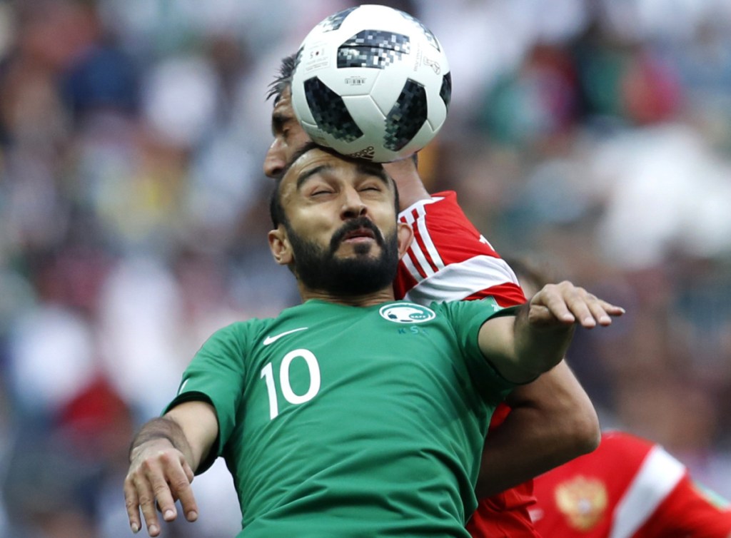 Mohammed Alsahlawi, foreground, of Saudi Arabia jumps for the ball Thursday with Alexander Samedov of Russia during the group A game at Moscow that opened the World Cup.