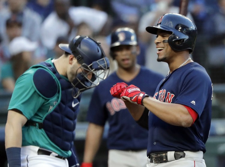Boston's Xander Bogaerts smiles as he crosses the plate after hitting a three-run home run during the third inning in Seattle on Friday night.