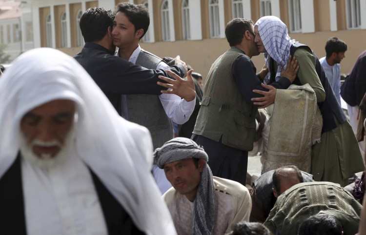 Men hug each other after Eid al-Fitr prayers outside of Shah-e-Dushamshera mosque in Kabul, Afghanistan, on Friday. The Taliban announced a three-day cease-fire starting the first day of Eid.
