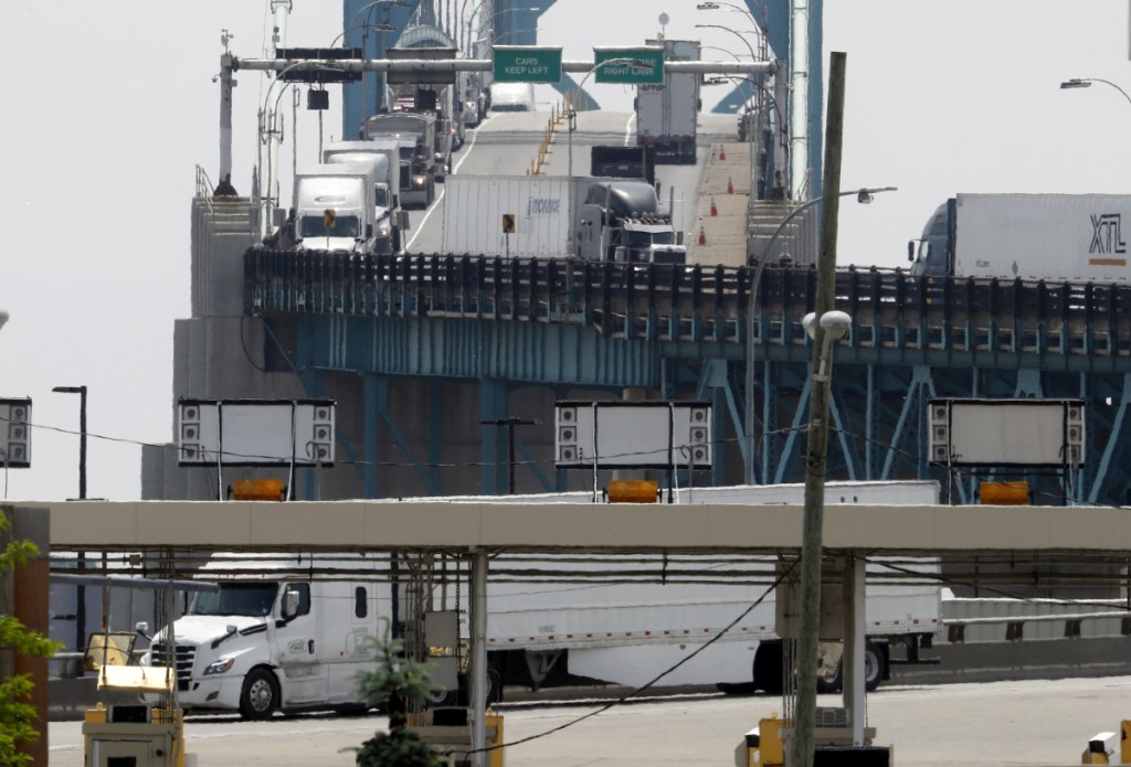Trucks cross the Ambassador Bridge from Windsor, Ontario, into Detroit. In nearly a quarter-century since NAFTA was approved, a complex chain of auto parts makers has sprung up on both sides of the border.