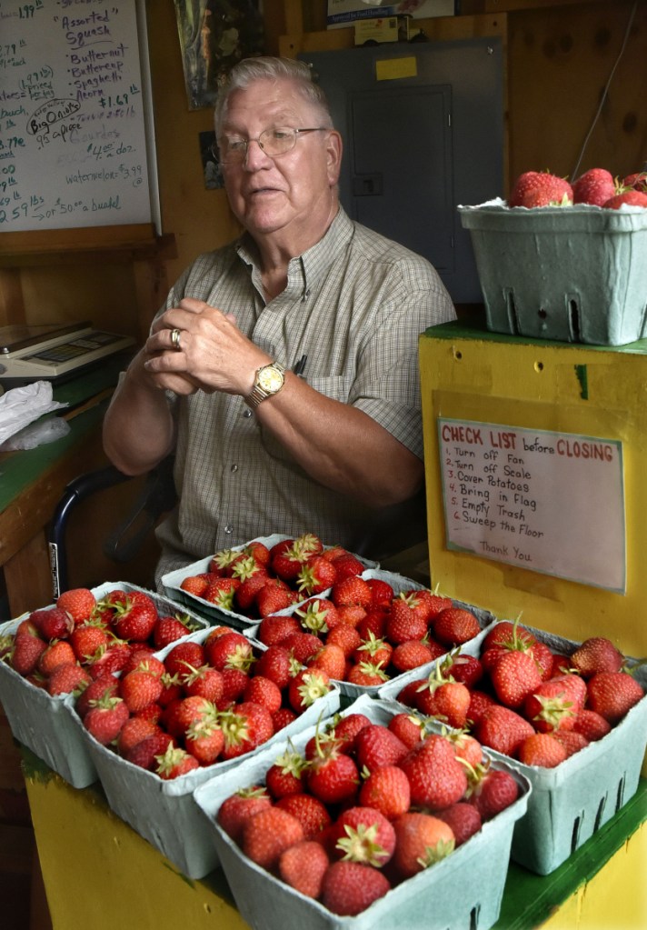 Dan Dutil speaks with a customer at the produce stand at the Underwood Strawberry Farm in Benton on Monday. Customers can purchase picked berries or pick their own. Owner Chuck Underwood said this years crop is in good shape and at least 10 days earlier than past years.