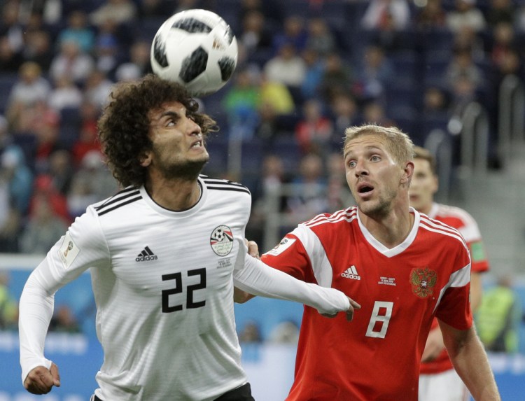 Russia's Yuri Gazinsky, right, challenges for the ball with Egypt's Amr Warda during the match between Russia and Egypt at the 2018 World Cup in the St. Petersburg stadium in St. Petersburg, Russia on Tuesday.