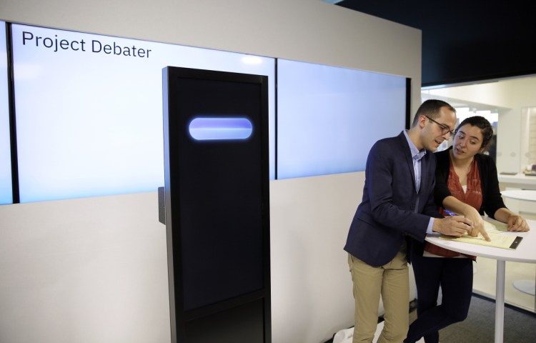 Champion debaters Dan Zafrir, left, and Noa Ovadia, right, prepare their arguments against the IBM Project Debater, at left, on Monday in San Francisco. The demonstration aimed to show that computers are getting better at responding to human language and speech.