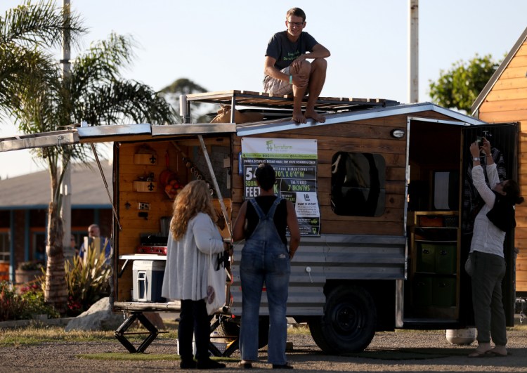 Richard Ward chats with attendees about the boat trailer he converted into a tiny home that he lives in full-time during TinyFest California at the Santa Clara County Fairgrounds in San Jose, Calif., on Friday. The weekend-long event showcases the tiny house movement.