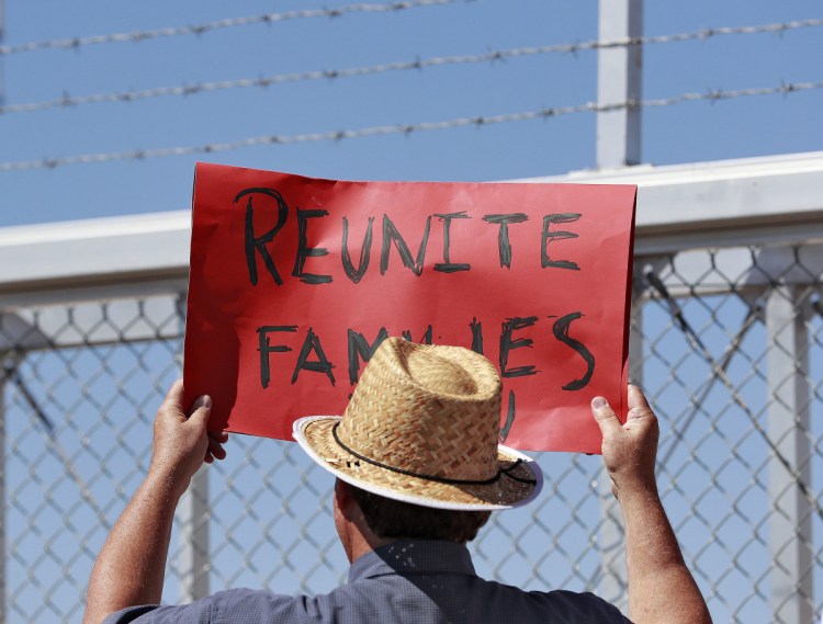 A protester holds a sign Thursday at the port of entry in Fabens, Texas, where separated families reside in tent shelters. A reader is outraged that tax dollars are funding this appalling program.