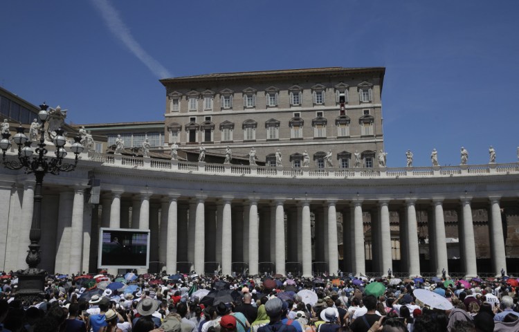 Faithful listen to Pope Francis as he recites the Angelus noon prayer from the window of his studio overlooking St. Peter's Square, at the Vatican on Sunday, June 17.