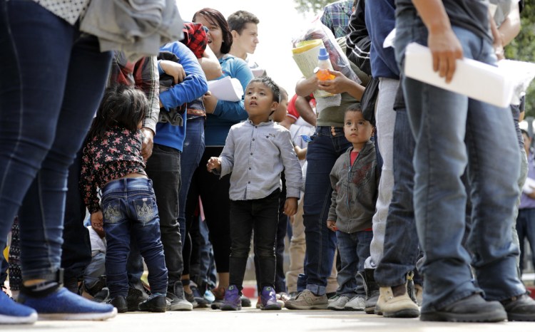 Immigrant families line up to enter the central bus station after they were processed and released by U.S. Customs and Border Protection on Sunday in McAllen, Texas. The Department of Homeland Security and the Department of Health and Human Services said 522 children have already been returned to their parents.