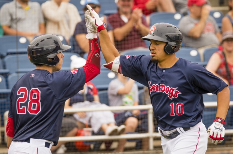 Portland designated hitter Luke Tendler, right, is congratulated by teammate Austin Rei after Tendler hit a solo home run in seventh inning during the Sea Dogs' 5-4 win over the Trenton Thunder on Sunday at Hadlock Field.