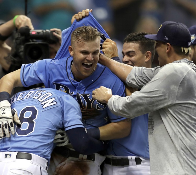 Jake Bauers of the Tampa Bay Rays, center, celebrates with teammates Sunday after hitting the 12th-inning homer that beat the New York Yankees.