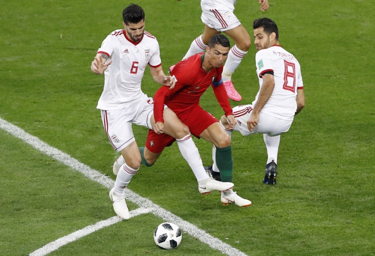 Portugal's Cristiano Ronaldo, bottom, is fouled by Iran's Saeid Ezatolahi during their Group B match against Portugal on Monday at the World Cup at the Mordovia Arena in Saransk, Russia.