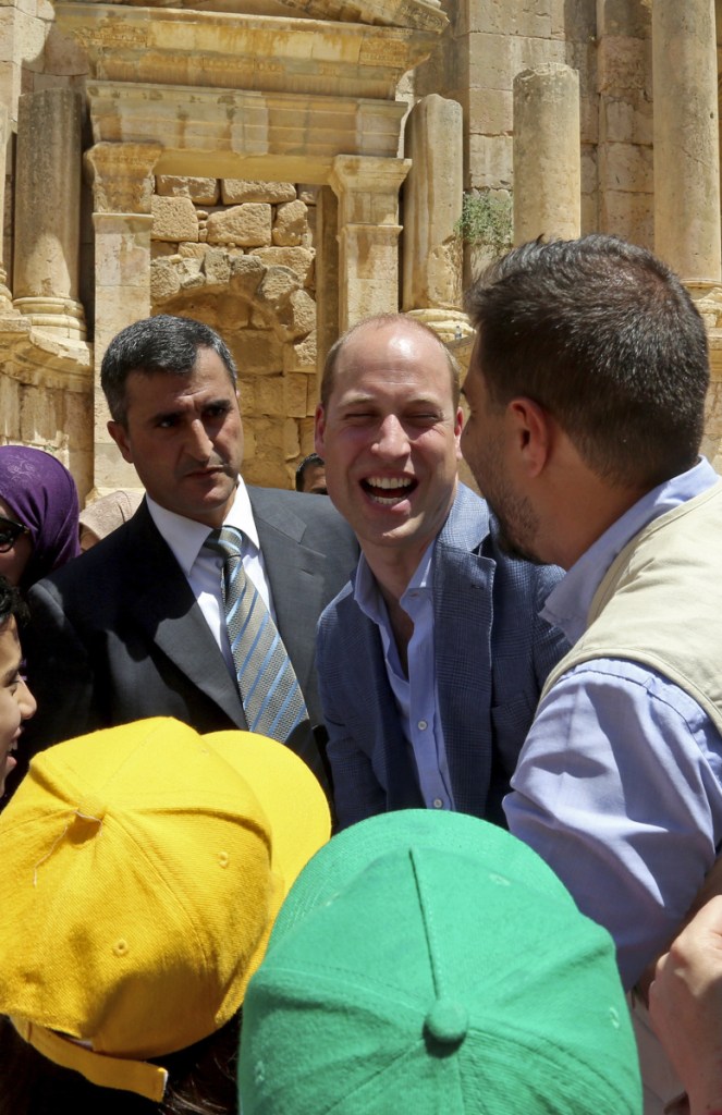 Britain's Prince William, center, laughs with a group of young people at an archaeological site in Jerash, northern Jordan, Monday.