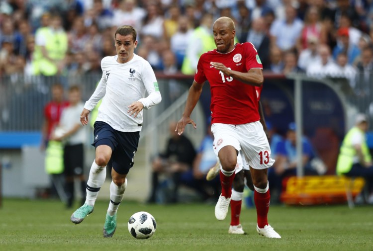 France's Antoine Griezmann vies for the ball with Denmark's Mathias Jorgensen during the group C match between Denmark and France at the 2018 World Cup in Moscow on Tuesday.  The teams played to a scoreless draw and drew boos and whistles from the crowd.