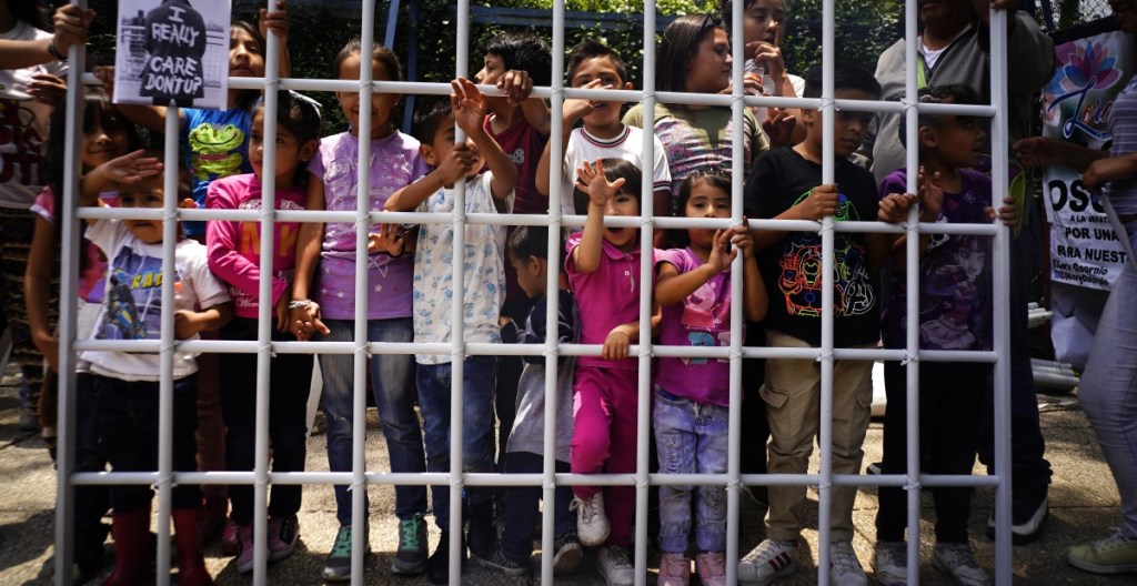 Children hold up a metal fence in Mexico City on Tuesday to protest immigrant children being detained by U.S. immigration authorities. The protest was organized by Lorena Osorio, independent candidate for Mexico City mayor ahead of July 1 elections.