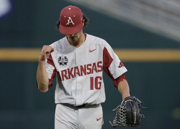 Arkansas pitcher Blaine Knight pumps his fist as he walks off the mound after the sixth inning of Game 1 of the NCAA College World Series against Oregon State Tuesday night in Omaha, Neb.