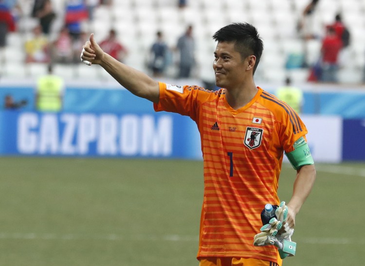 Japan goalkeeper Eiji Kawashima celebrates after his team advanced to the knockout phase of the World Cup despite its 1-0 loss Thursday against Poland.