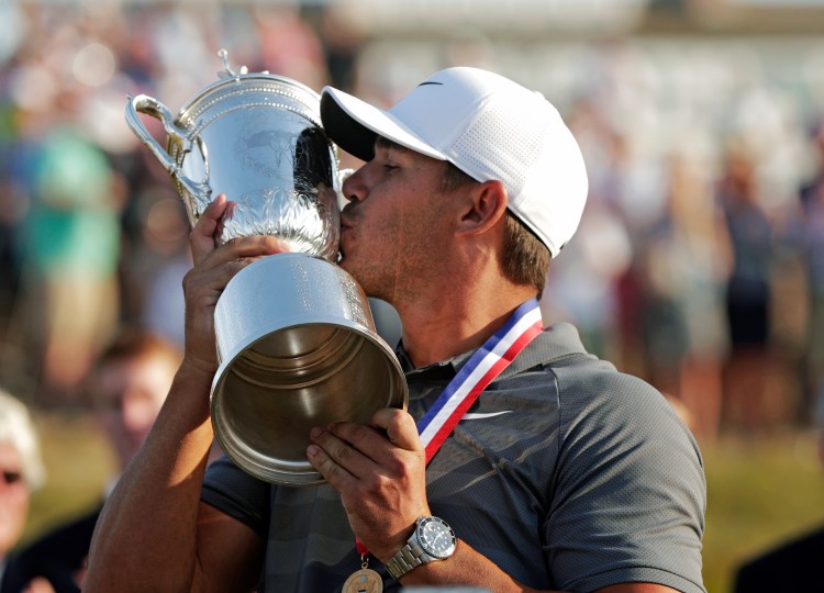 Brooks Koepka kisses the trophy after winning his second straight U.S. Open on Sunday in Southampton, N.Y. 