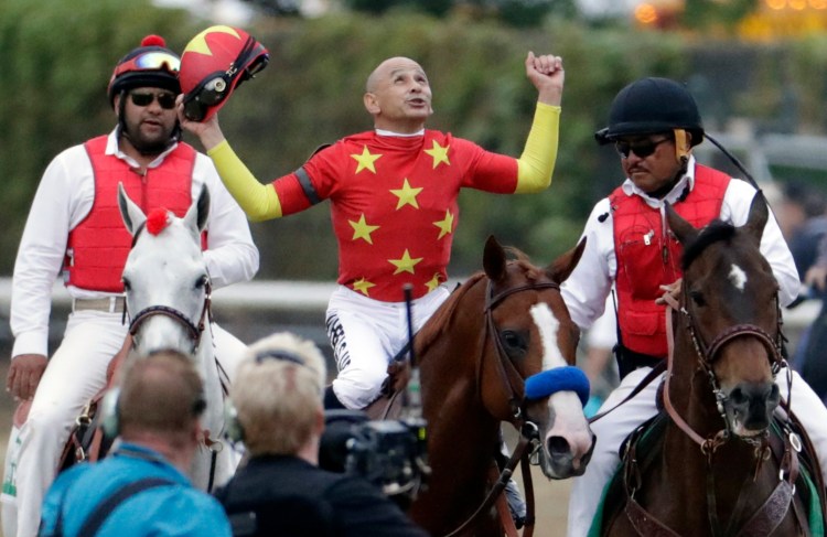 Jockey Mike Smith, center, celebrates atop Justify and the pair teamed up to win the Belmont Stakes on Saturday in Elmont, N.Y. Justify will get a rest before racing again.