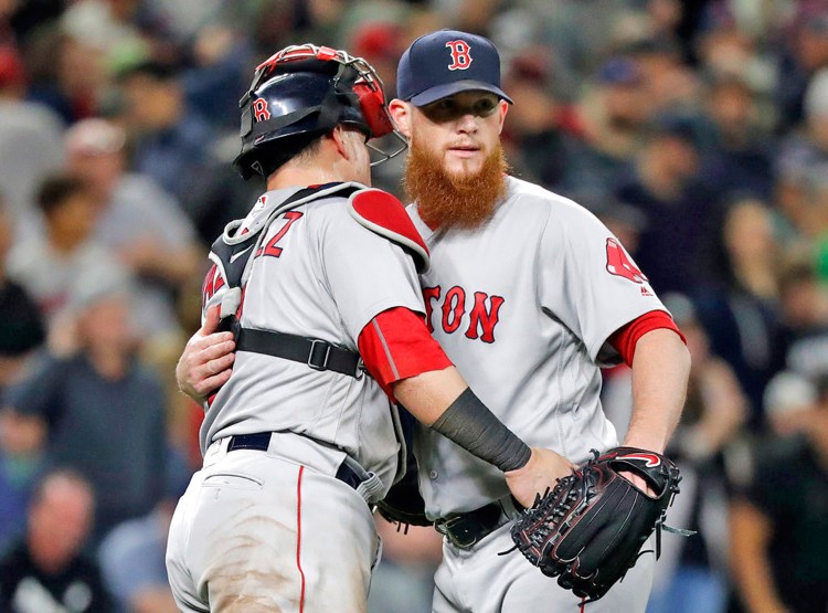 Red Sox closing pitcher Craig Kimbrel embraces catcher Christian Vazquez after the Red Sox defeated the Seattle Mariners 2-1.