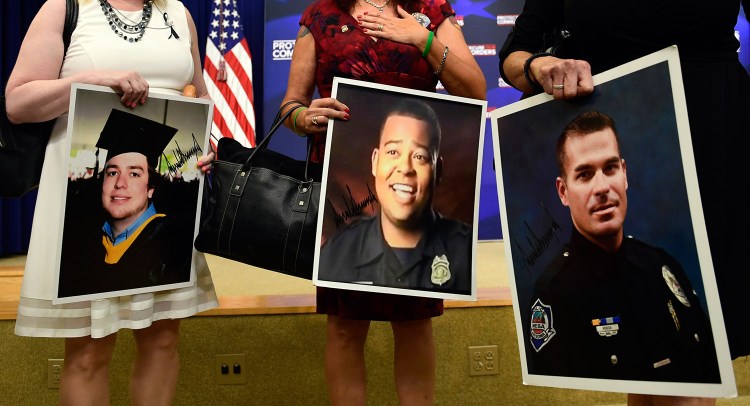 People holding photos of victims arrive for a White House event about crimes committed by undocumented immigrants, in Washington on Friday. President Trump arranged the session to push back against critics of his immigration policy.