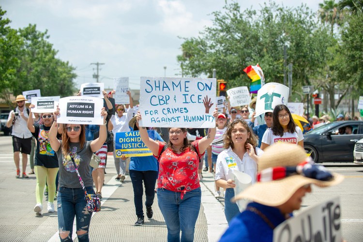 Demonstrators participate in an organized march Saturday near the Gateway International Bridge in downtown Brownsville, Texas, to protest the treatment of immigrants coming across the border.