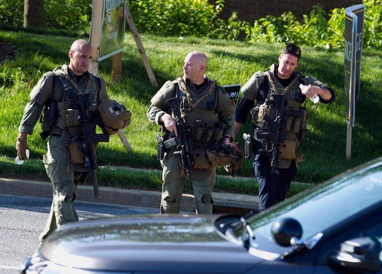 Police officers at the scene Thursday after multiple people were shot at the Capital Gazette newspaper office building in Annapolis, Md. Authorities were searching an apartment late Thursday tied to suspect Jarrod W. Ramos, 38.