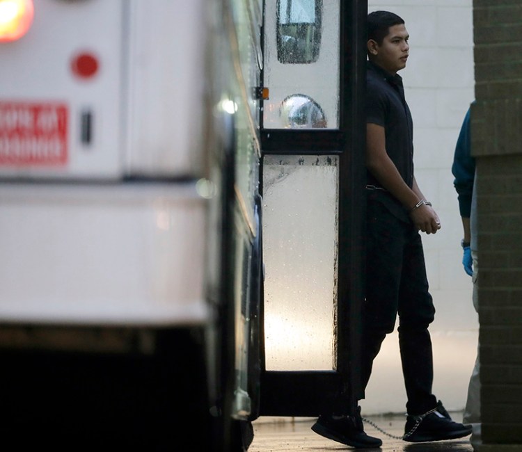 Immigrants in handcuffs and ankle chains arrive at the Federal Courthouse for hearings on Thursday in McAllen, Texas. 