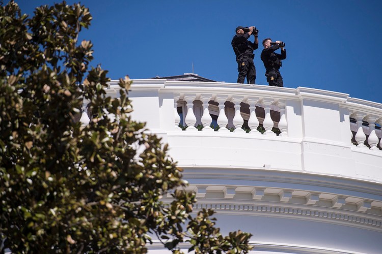 Members of the Secret Service patrol the top of the White House in 2015.