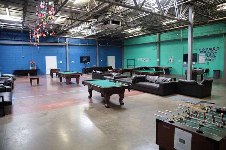 Children can play pool and foosball in a rec room at Casa Padre. Bedrooms are doorless, with walls reaching only halfway to a 20-foot-high industrial ceiling. 

