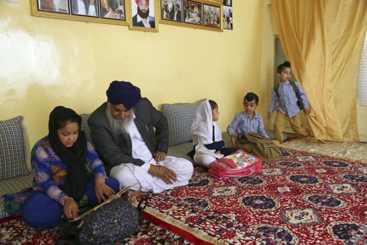 Avtar Singh Khalsa, a Sikh and longtime leader of the community, studies with his grandchildren at home, in Kabul, Afghanistan, on June 7. 
