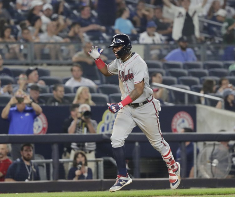 Ronald Acuna Jr. celebrates as he runs the bases after hitting a two-run home run in the 11th inning to lift the Braves to a 5-3 win over the Yankees on Monday in New York.